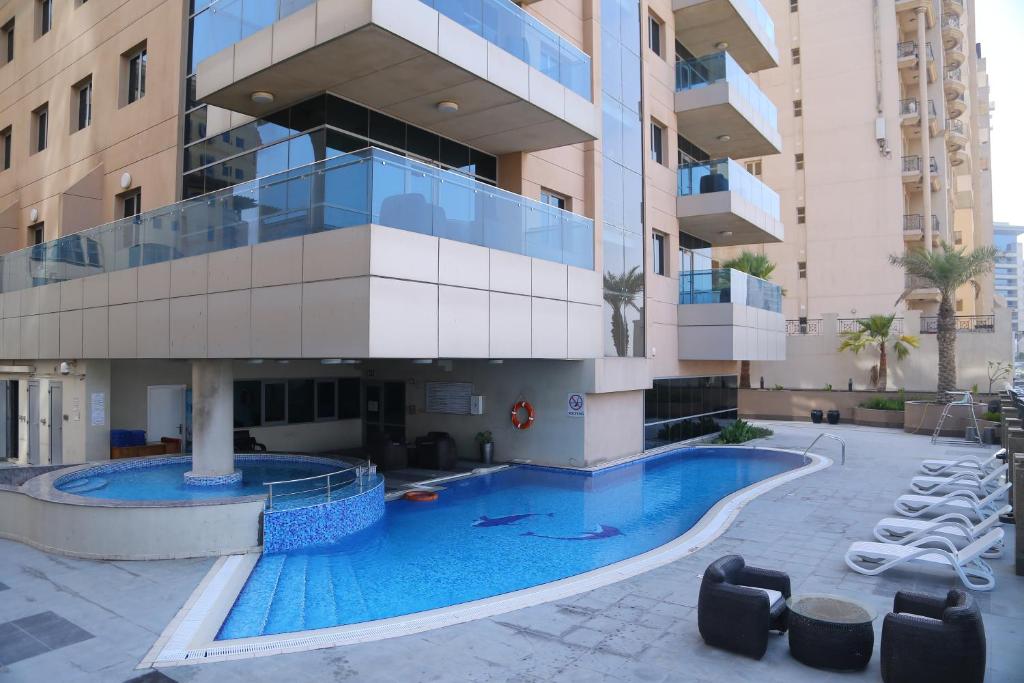 迪拜Tulip Creek酒店式公寓的建筑前的一座带游泳池的建筑