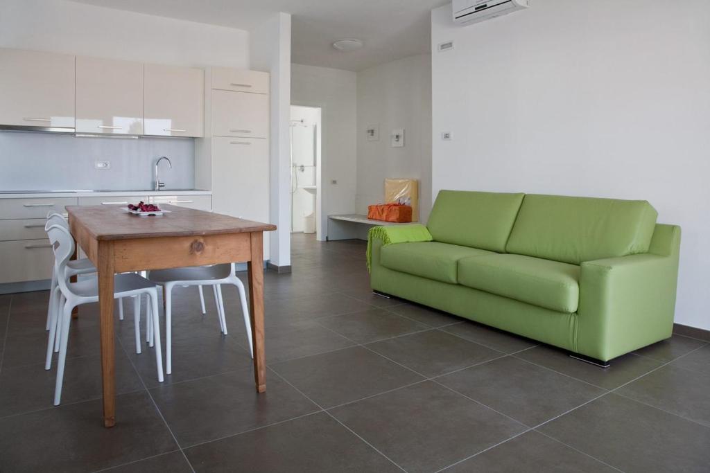 托尔博莱Casa Rosa dei Venti的客厅配有绿色沙发和桌子