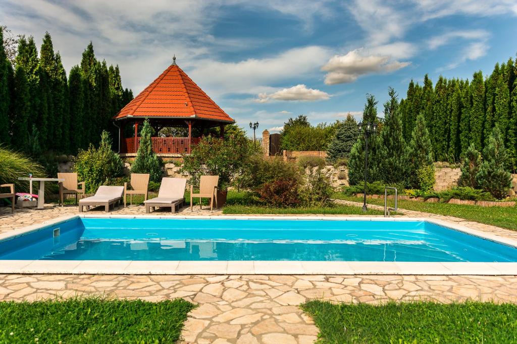 PalkonyaBella Vendégház Palkonya的一个带凉亭的庭院内的游泳池