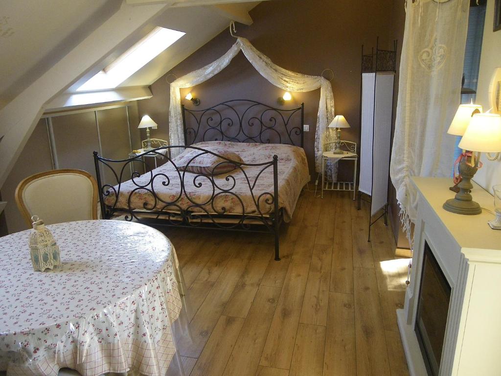 班什Au gîte de Binche的一间卧室配有一张床和两张桌子