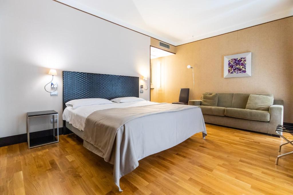 那不勒斯MH设计酒店的酒店客房,配有床和沙发