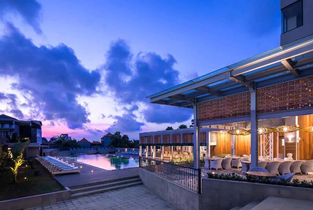 坎古Eastin Ashta Resort Canggu的享有带游泳池的建筑的外部景色
