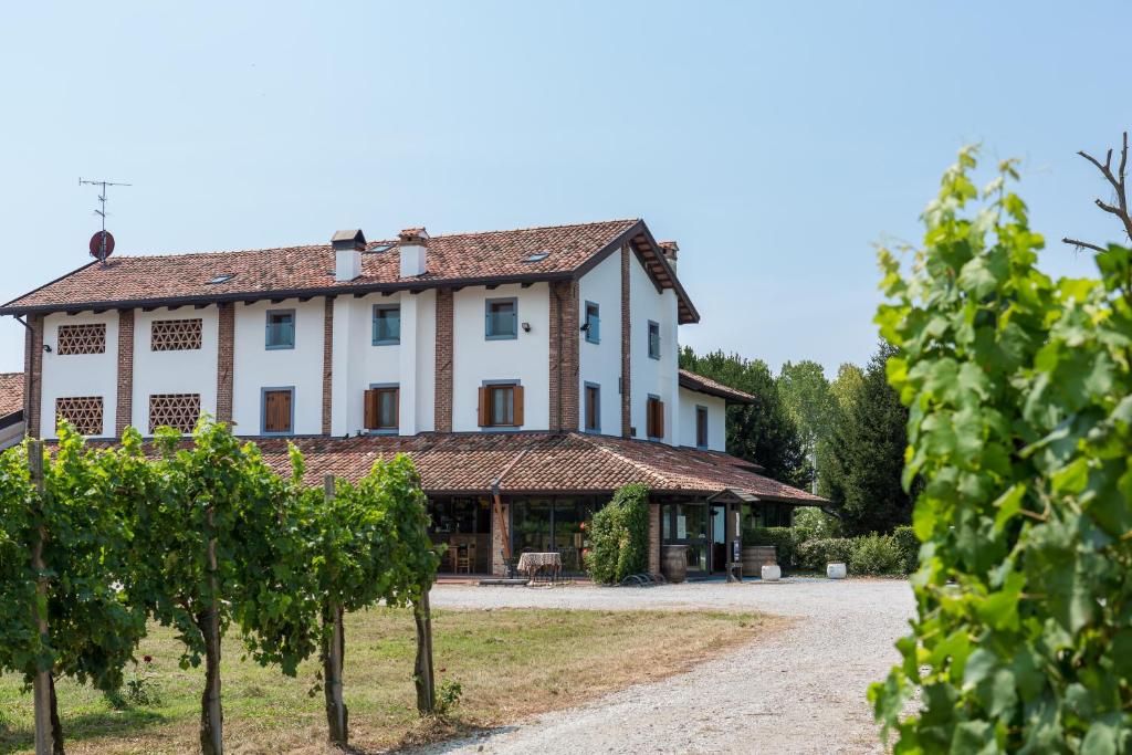 Pozzuolo del FriuliAgriturismo Cjasal di Pition的前面有树木的白色大建筑