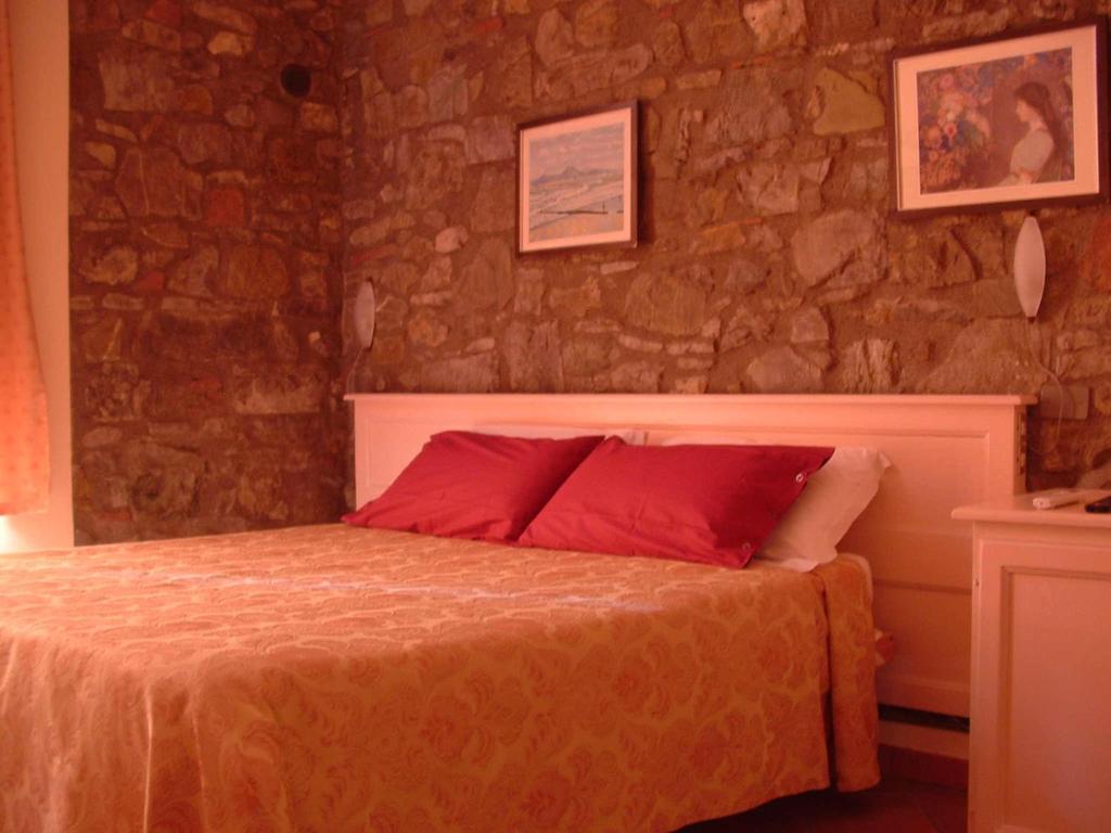基安蒂格雷夫盖罗洛肯达酒店Il的一间卧室配有红色枕头的床