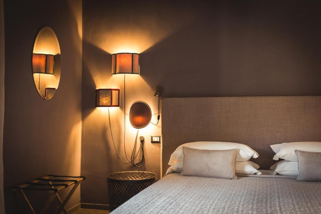 维杰瓦诺皮卡罗托雷旅馆的卧室配有一张床,墙上有两盏灯