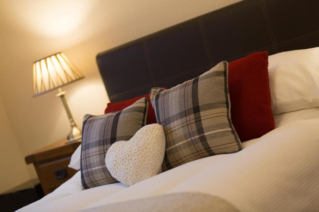 阿伯丁Cedars Guest House的一间卧室配有一张带枕头和心枕的床