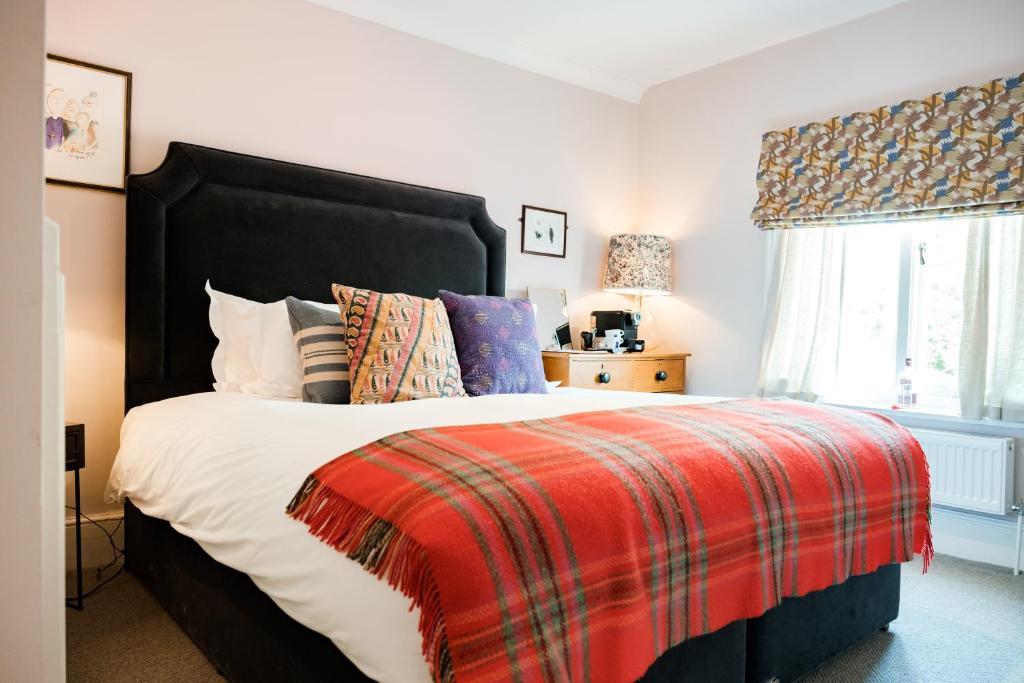 库克姆Bel and The Dragon-Cookham的一间卧室配有一张带红色毯子的大床