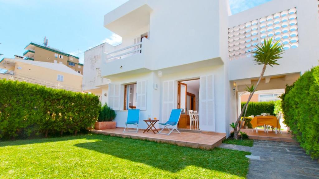 穆罗海滩Casa GAVINES Alcudia的房屋设有庭院、两把椅子和庭院