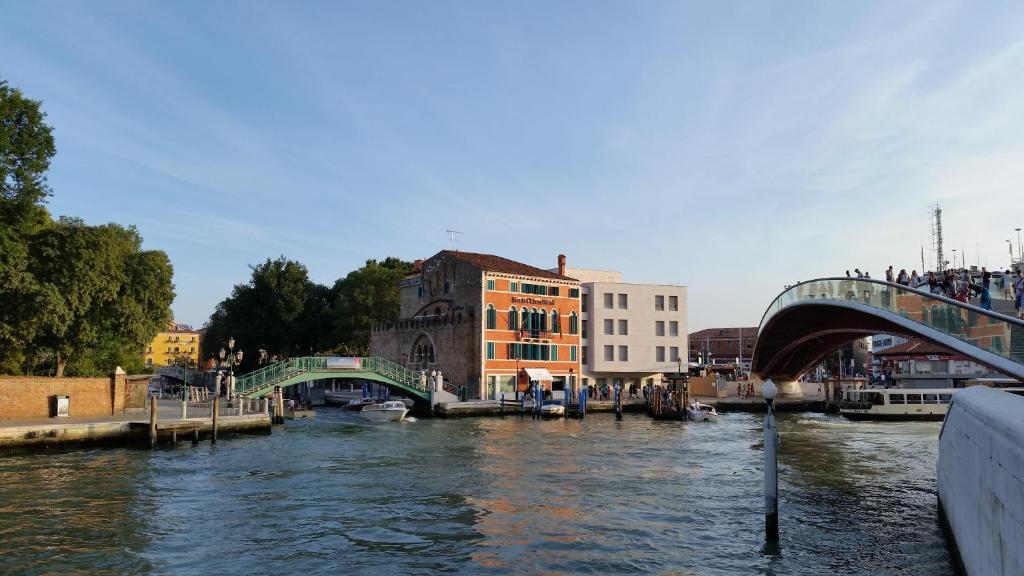 威尼斯Hotel Santa Chiara的享有河流、桥梁和建筑的景色