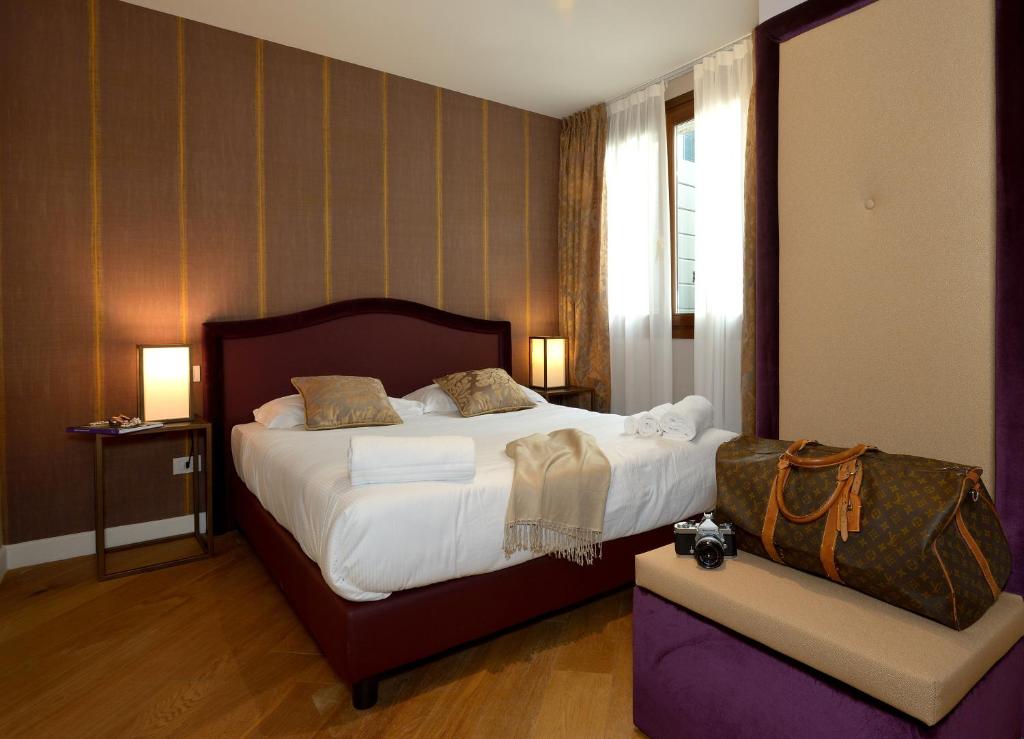 威尼斯凤凰公寓式酒店的一间设有大床和窗户的酒店客房