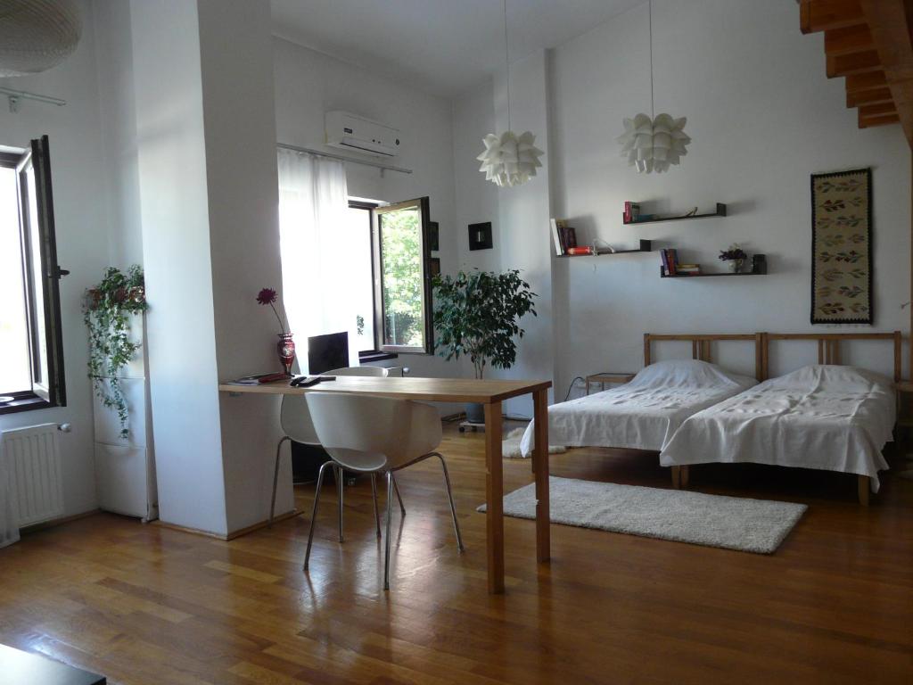 布加勒斯特Cosy studio 55sqm, Cotroceni Area的客厅配有桌子和床。