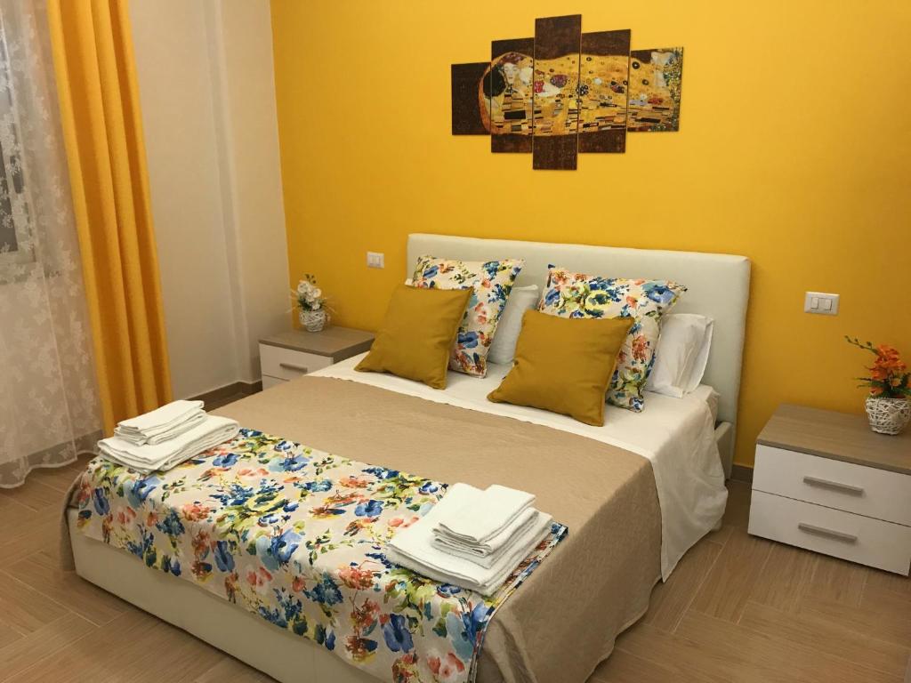 卡塔尼亚Holiday In Home | Le Ciminiere的一间卧室设有一张床和黄色的墙壁