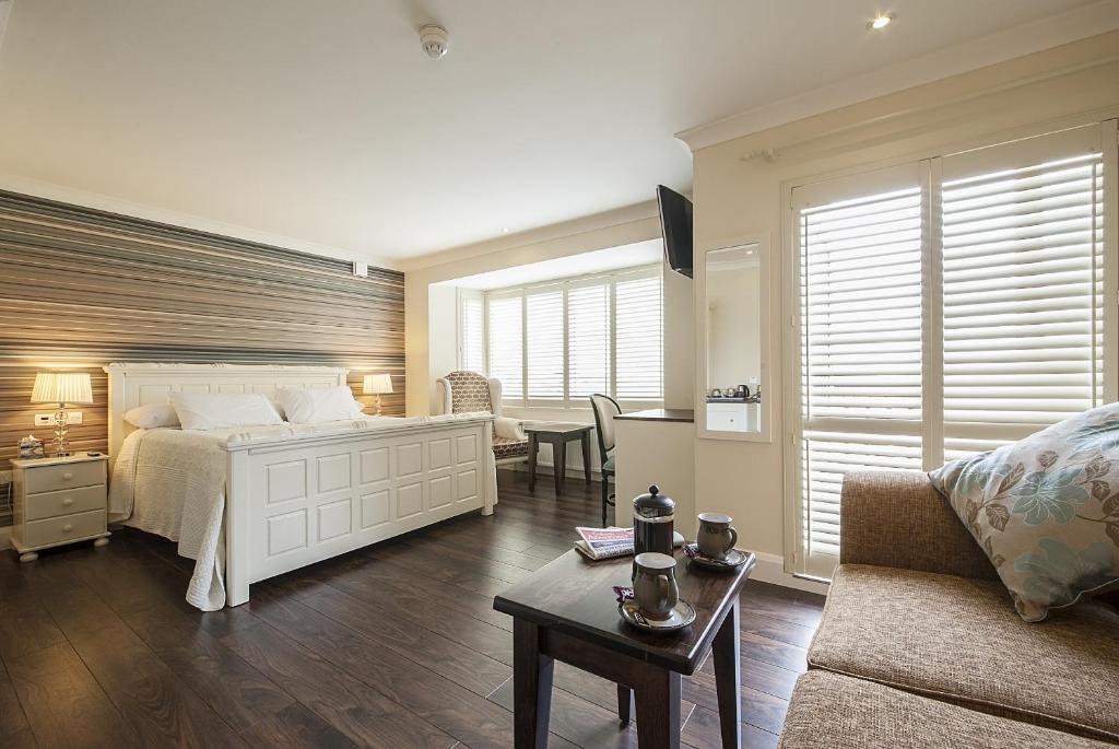 戈尔韦Sea Breeze Lodge B&B Galway的一间卧室配有一张床、一张沙发和一张桌子