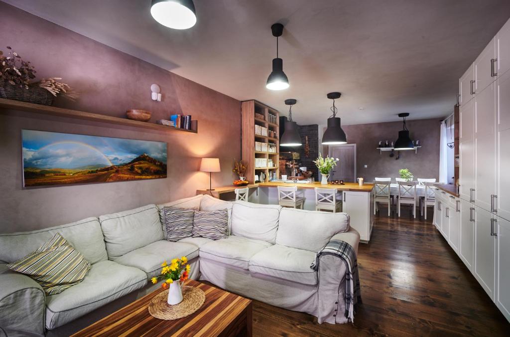 班斯卡 - 什佳夫尼察Sad nad Klingerom的一间带白色沙发的客厅和一间厨房