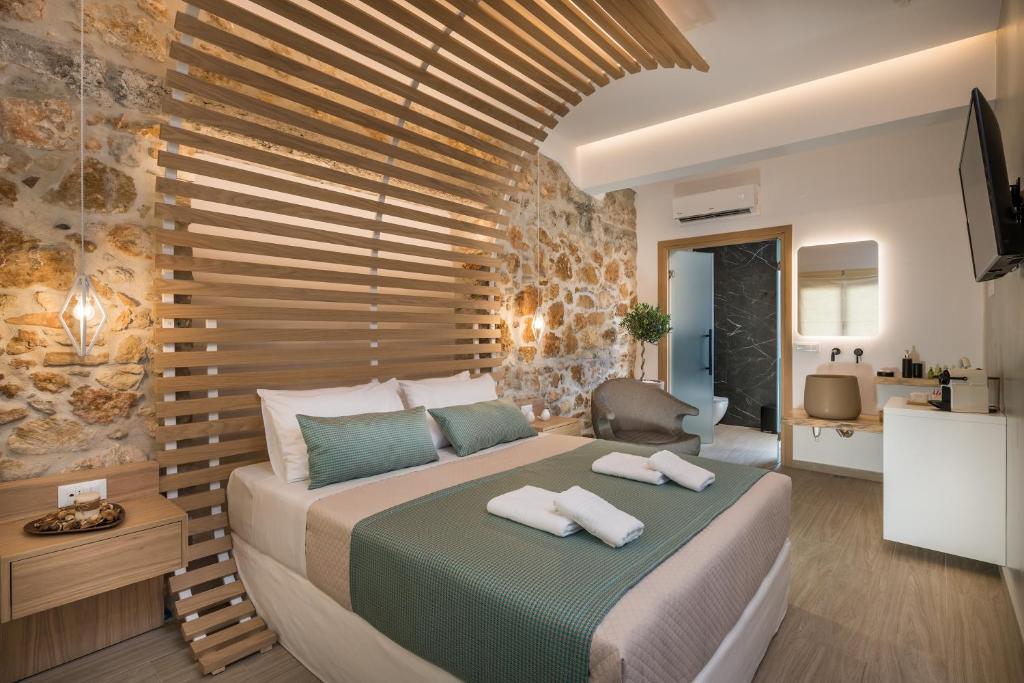 干尼亚Agave Suites的一间卧室设有一张带木墙的大床
