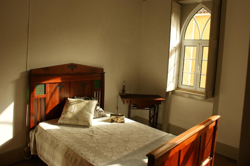 卢索157 Rua Emídio Navarro的一间卧室设有一张木床和一个窗户。