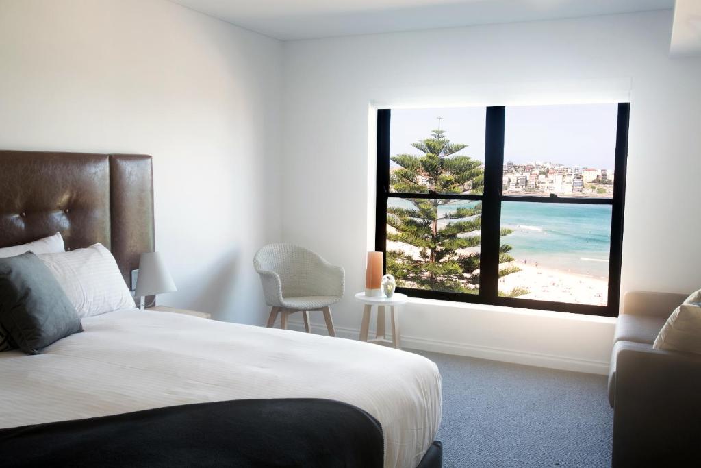 悉尼邦迪38号服务式公寓酒店的一间卧室配有一张床,享有海滩美景
