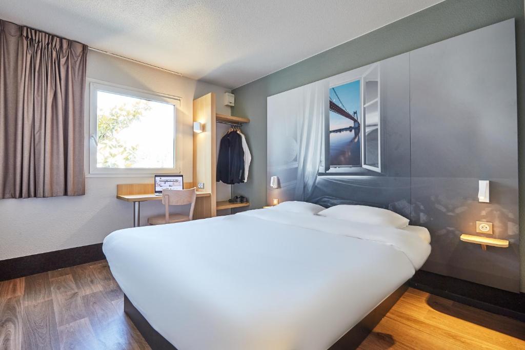 阿夫勒尔B&B HOTEL Le Havre Harfleur 1的卧室设有一张白色大床和一扇窗户。