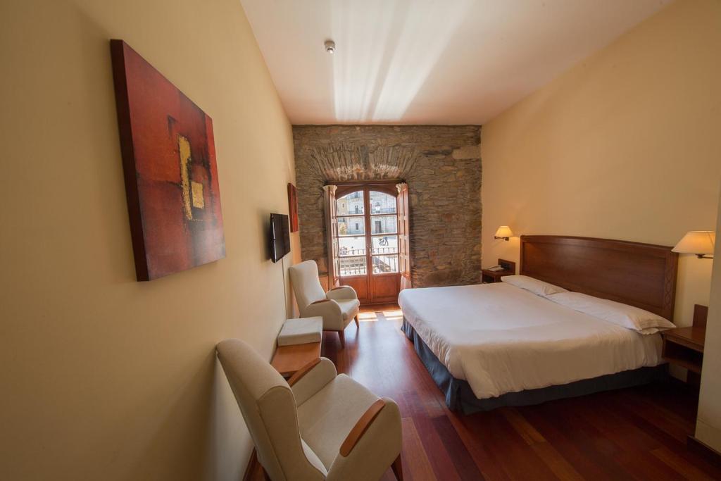 蓬费拉达埃洛伊比耶索广场酒店的酒店客房,配有一张床和两把椅子