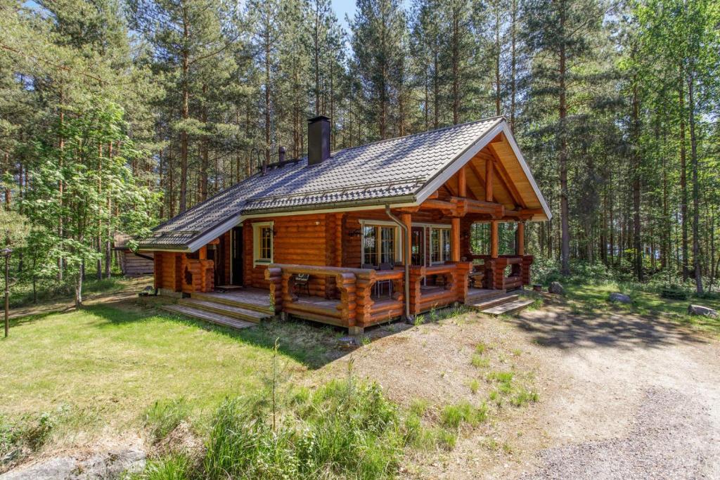 TammijärviNenäniemi的树林中的小木屋,设有门廊