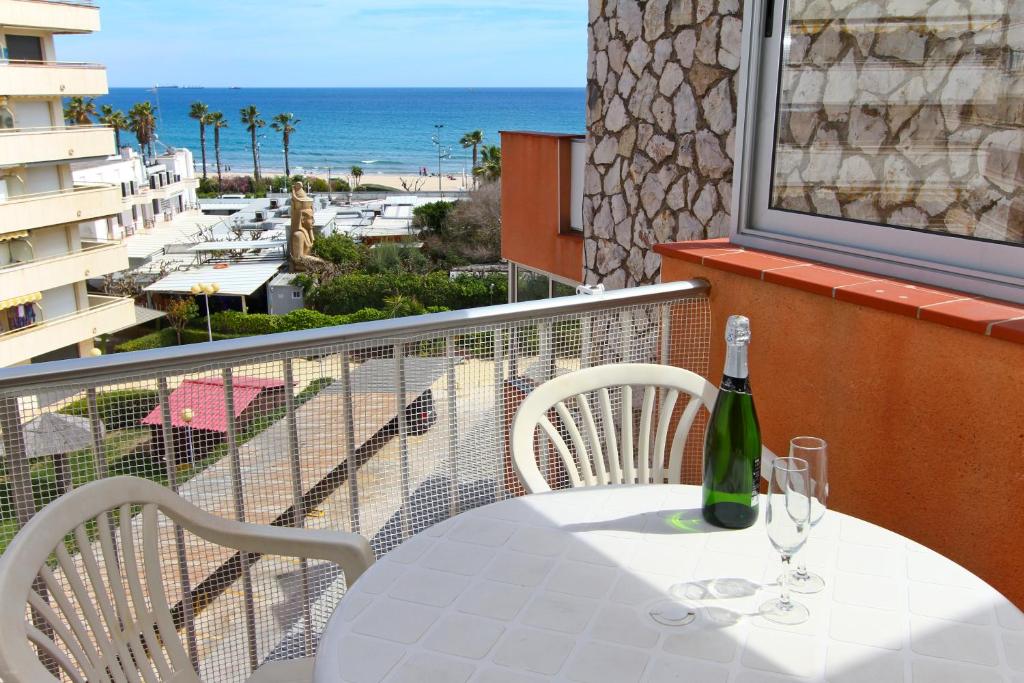 拉皮内达Dms Planet Costa Dorada的阳台上的桌子上放有一瓶和两杯酒