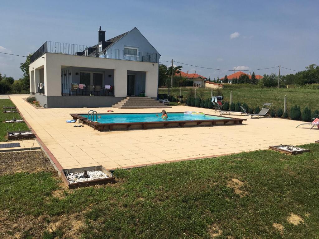 NemesbükkBalatonview - villa Myriam的房屋前有游泳池的房子