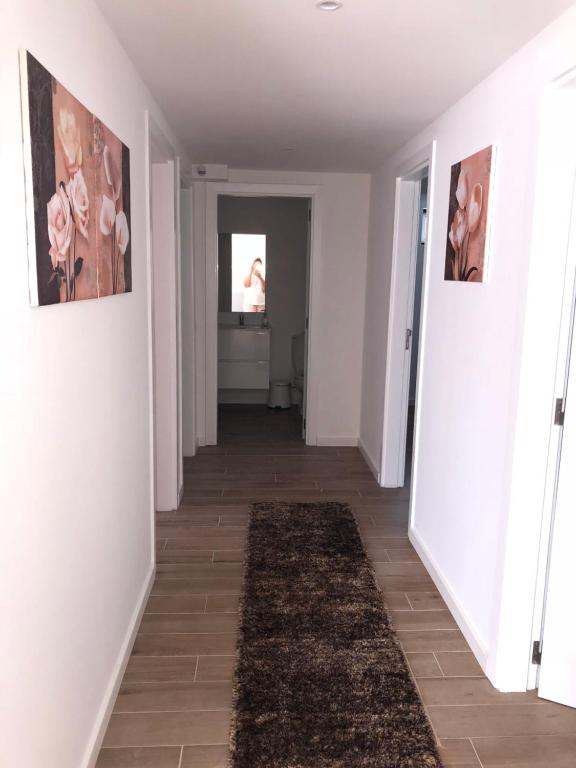 纳扎雷alojamento Xa andar的一条带白色墙壁和地毯的走廊