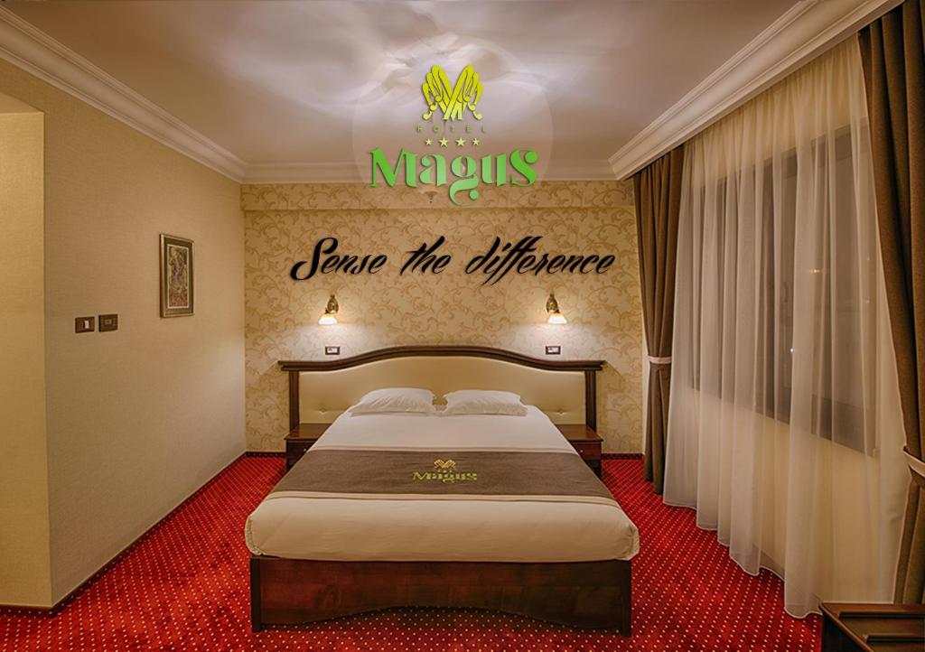 巴亚马雷Magus Hotel的酒店客房的墙上设有一张带标志的床