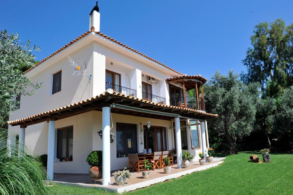斯基亚索斯镇Poseidon villa m ammos的一座带绿色庭院的大型白色房屋