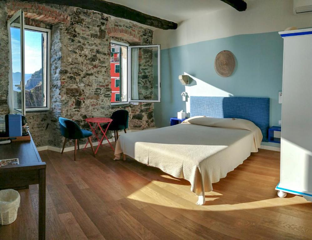 里奥马哲雷Orto al Mare Room Rental的卧室配有一张床和一张桌子及椅子