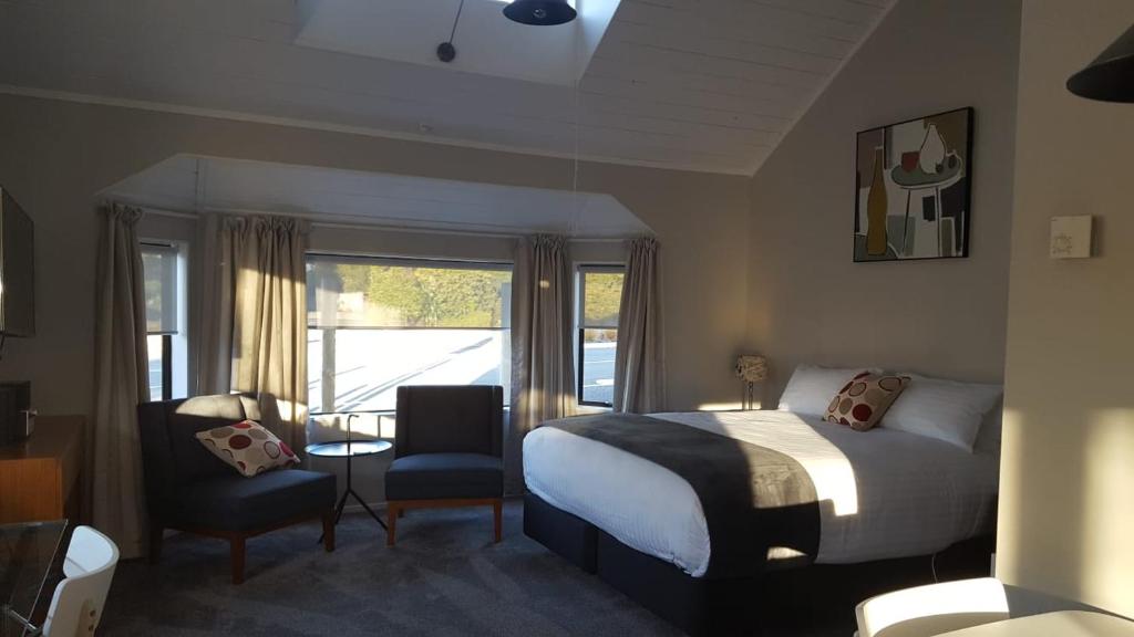 奥阿库尼The Ohakune Central Motels的卧室配有床、椅子和窗户。