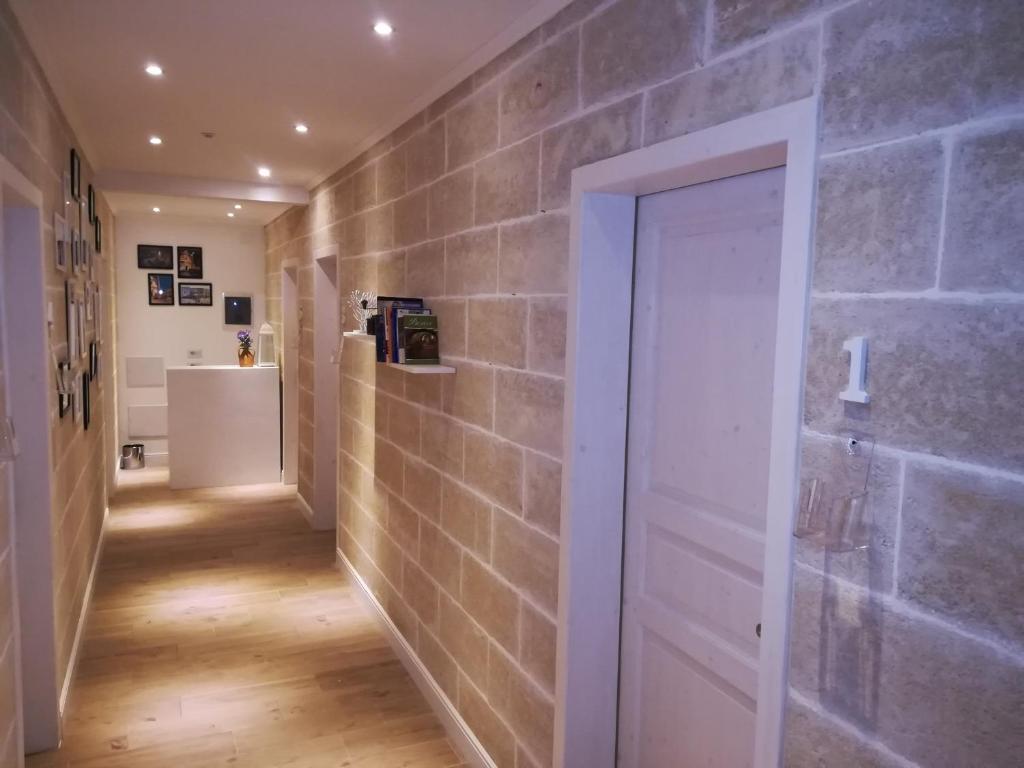 普雷西切B&B Suites Via del Mare的一条带砖墙和白色门的走廊