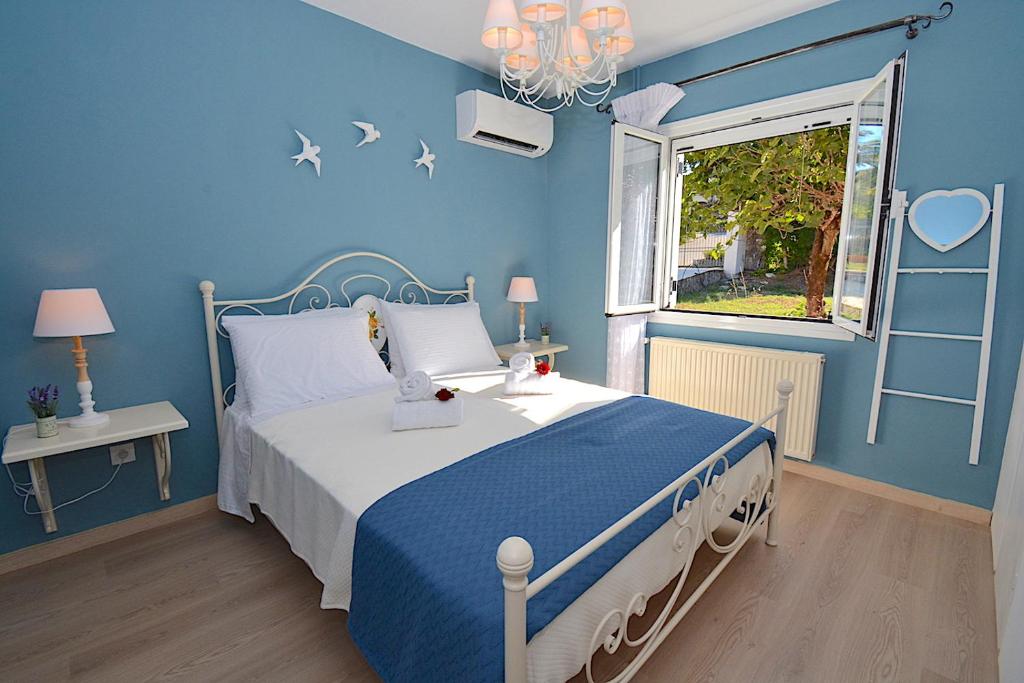 古维亚Villa Jasmine Blossom的蓝色的卧室设有床和窗户