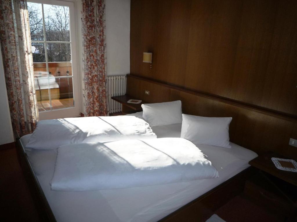 帕尔奇内斯Gasthof Stiegenwirt的一间卧室设有两张带白色床单的床和窗户。