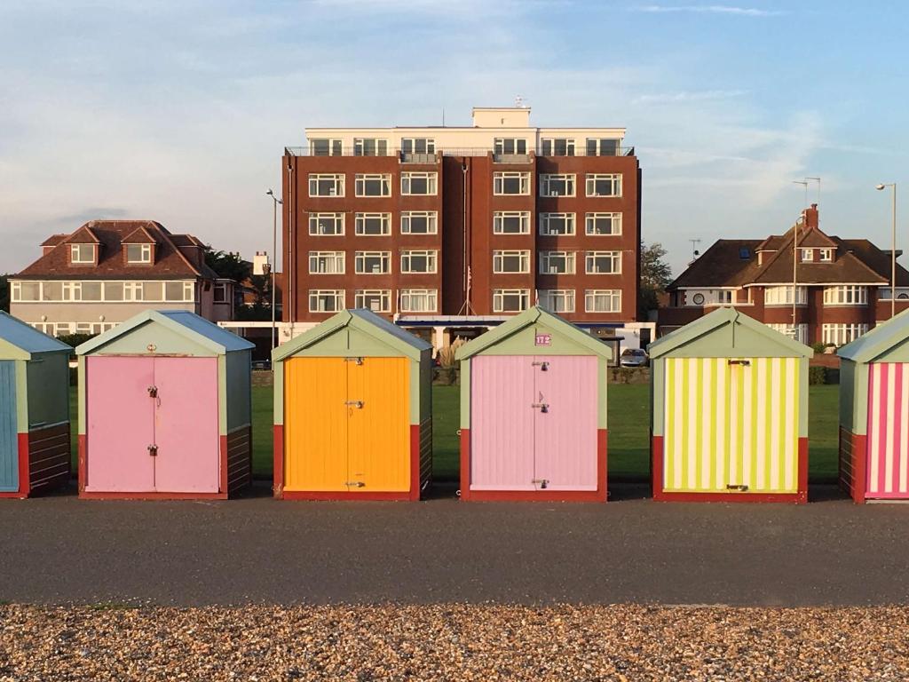 布莱顿霍夫贝斯特韦斯特王子海洋酒店的建筑物前一排色彩缤纷的海滩小屋