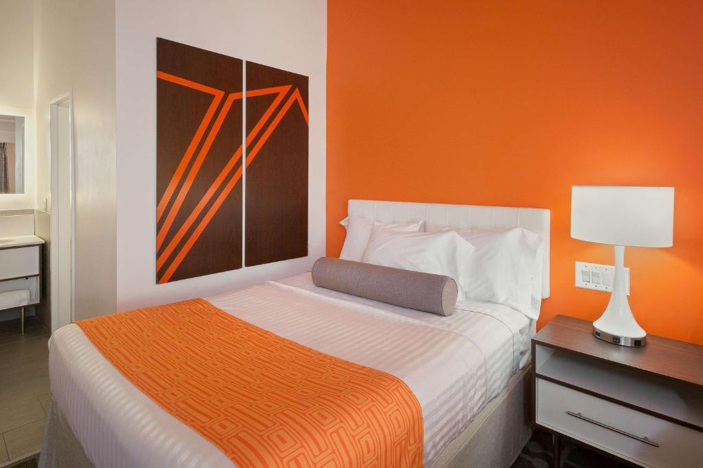 汤姆斯河汤姆斯河豪生国际酒店的一间卧室配有一张橙色墙壁的床