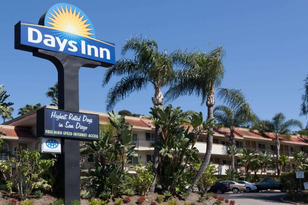 圣地亚哥Days Inn by Wyndham San Diego Hotel Circle的棕榈树酒店前的标志