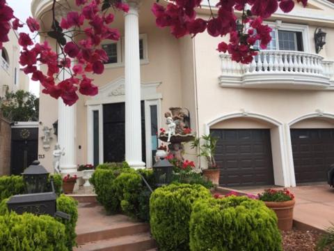 洛杉矶Entire Second Flr - Santa Monica Luxury Roman Villa的前面有一束鲜花的房子