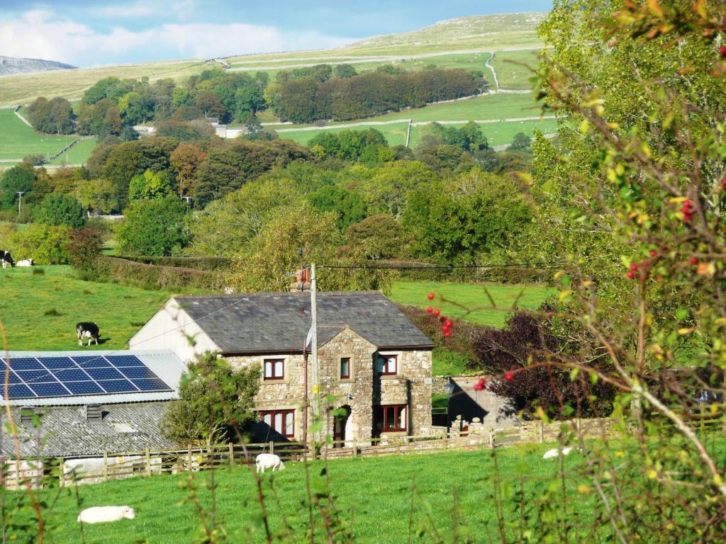 英格尔顿Nutstile Farm Bed and Breakfast的田野上太阳能电池板的房子