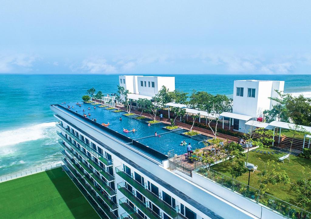 科伦坡科伦坡马里诺海滩酒店的一座带游泳池的建筑,毗邻大海
