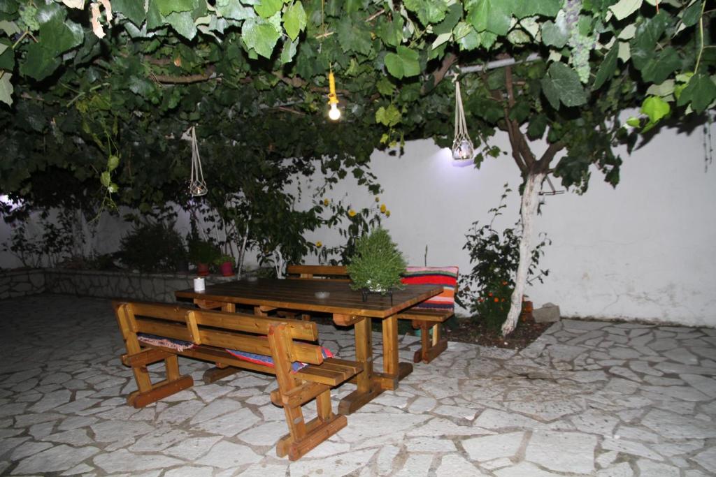 卡拉米锡Kondilw Rooms的一张野餐桌和树下的两张长椅