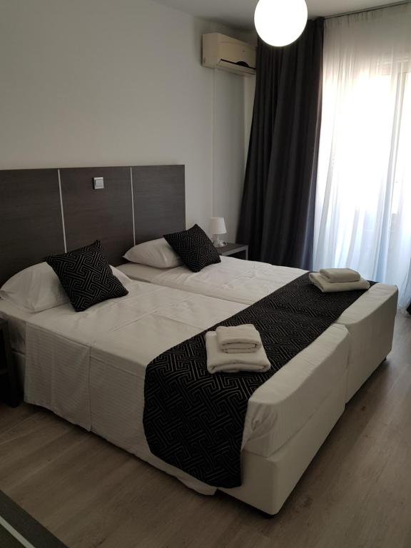 拉纳卡Les Palmiers Petrou Apartments的一间卧室配有两张带毛巾的床
