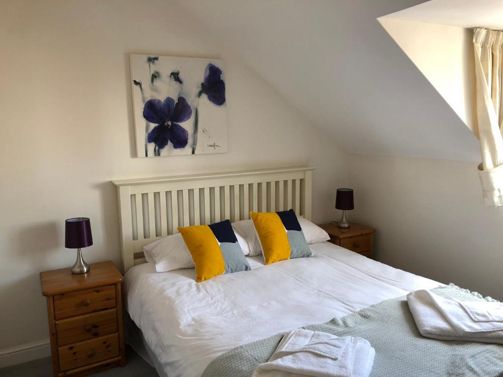 奥克姆Jubilee House的一间卧室配有黄色和白色枕头的床