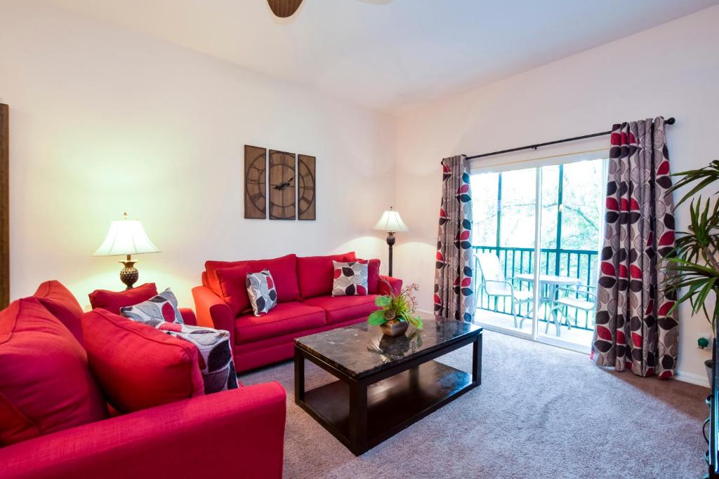 基西米Bahama Bay的客厅配有红色的沙发和桌子