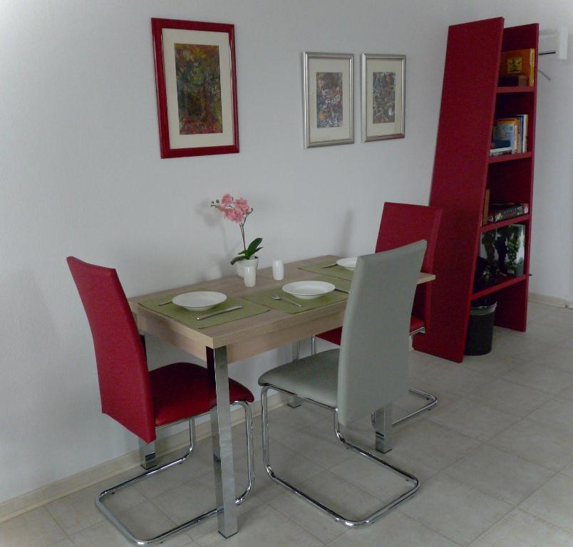 威斯巴登Ferienwohnung-Wiesbaden-Top3的一间带桌子和红色椅子的用餐室