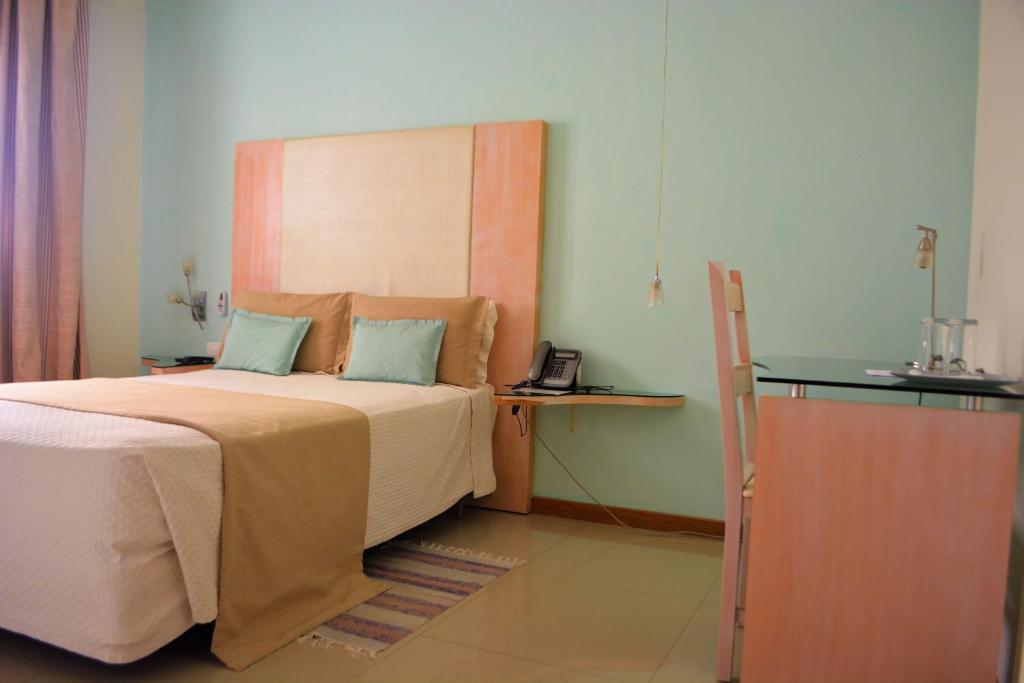 普拉亚Sol Hotel的一间卧室配有一张带木制床头板的床