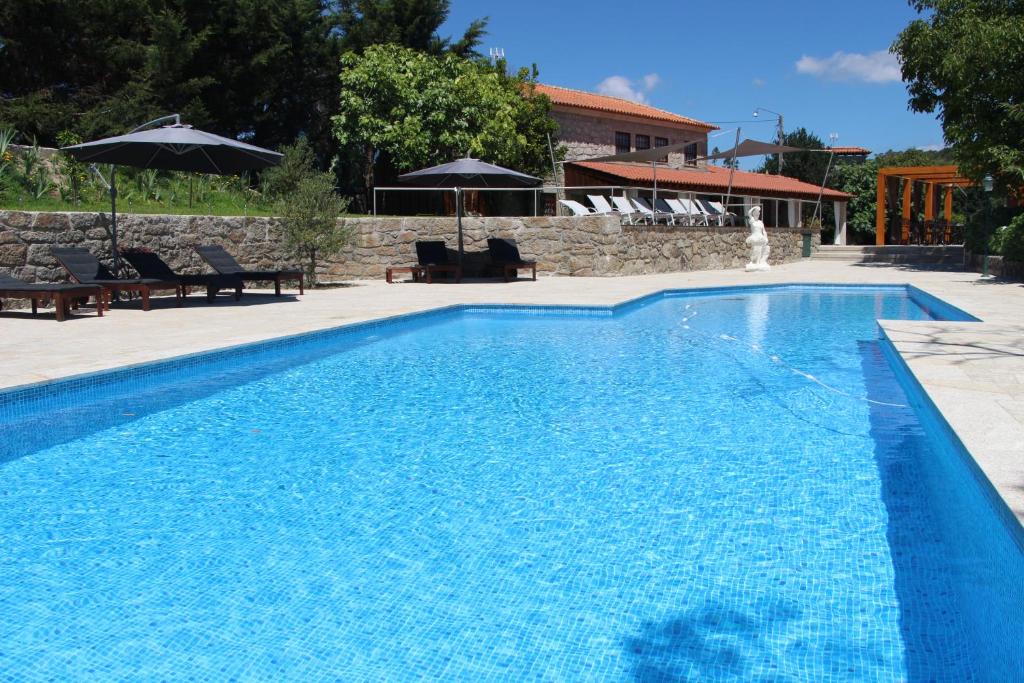 Cossourado里约之家旅馆的一座房子前面的蓝色海水游泳池