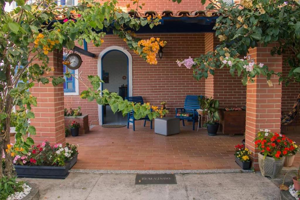 瓜拉派瑞Hostel Villa Virtudes的砖砌建筑,设有种有鲜花和植物的庭院