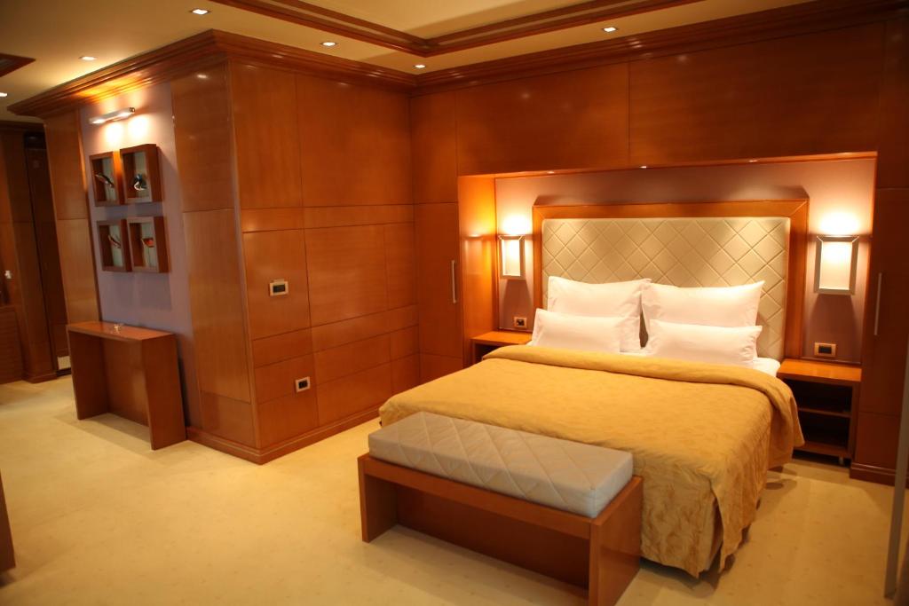 诺维萨德Garni Hotel Aleksandar的一间卧室配有一张带木墙的大床