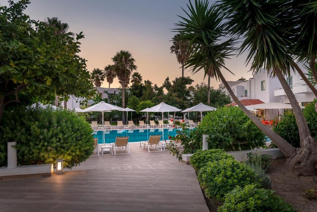 科斯镇亚历山德拉海滩酒店的度假酒店的游泳池配有椅子和遮阳伞